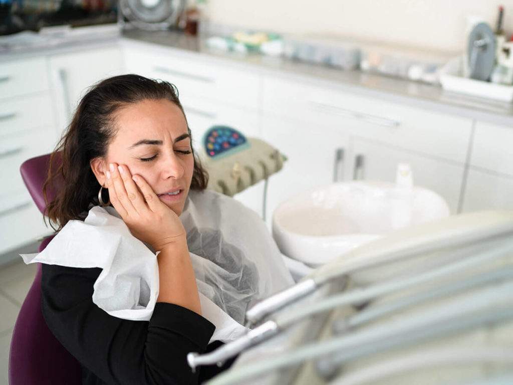 Woman in pain at office because of a dental emergency