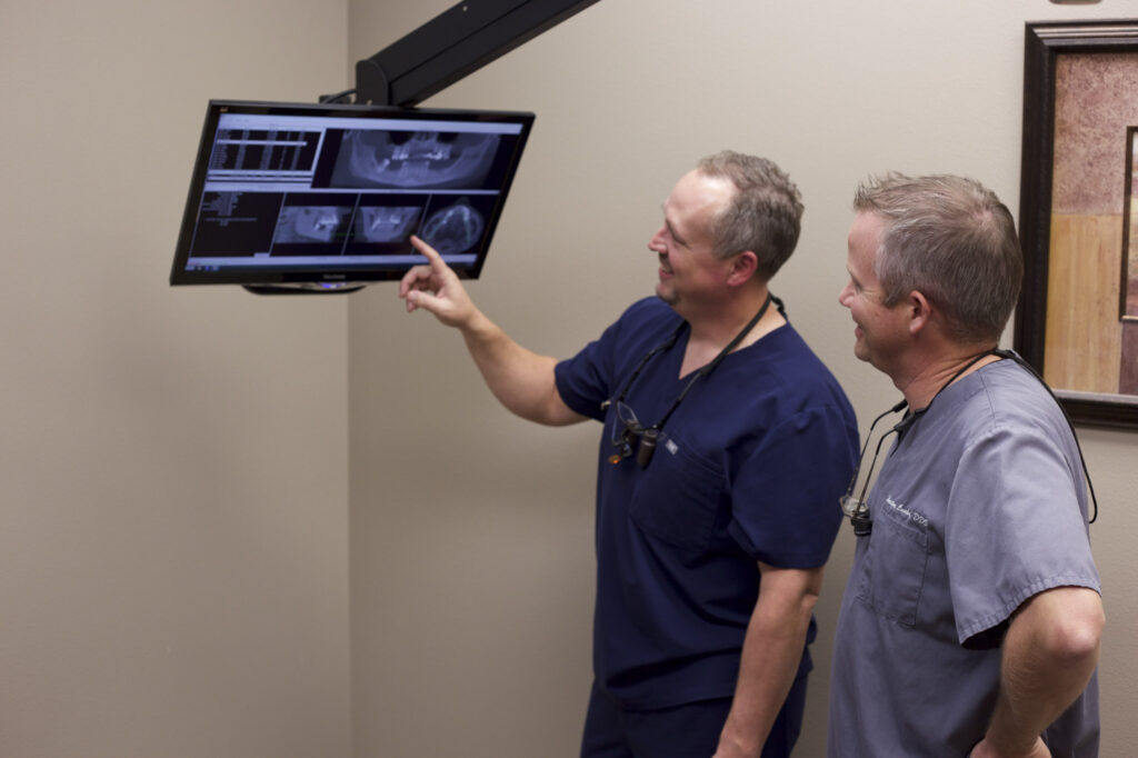 Dentists viewing x-ray of patient mouth.